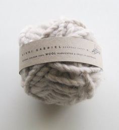 a ball of yarn with a label on it sitting on top of a white surface