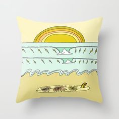 a yellow pillow with an image of a surfboard on the beach and clouds in the sky