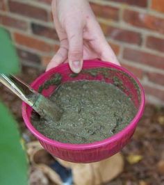 a person holding a pink bowl filled with green stuff