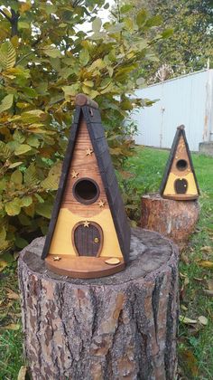 two bird houses sitting on top of a tree stump