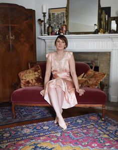 a woman sitting on top of a red couch