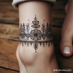 a woman's foot with a tattoo design on the top and bottom part of her leg