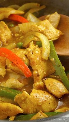 chicken and vegetable stir fry in a pan with wooden spoon