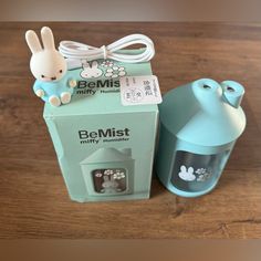 a box with a bunny on it next to a cup and an earbud