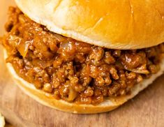 a sloppy joe sandwich on a wooden cutting board