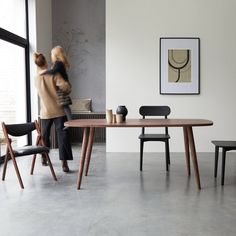 two people are standing near a table with chairs