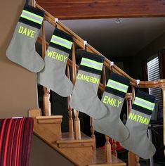 christmas stockings hanging from the banisters in front of stairs with name written on them