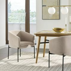 a dining room table with two chairs and a bowl on top of it, in front of a large window