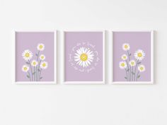 three purple and yellow flowers are on the wall next to two white framed art pieces