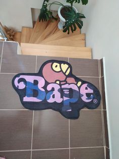 a sticker that says babe on the floor next to a potted plant and stairs