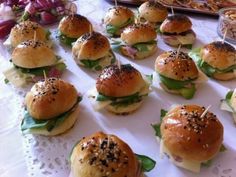 small sandwiches with toothpicks in them on a white tablecloth covered table cloth