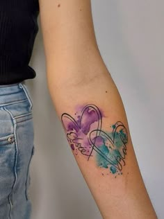 a woman's arm with two hearts and an angel tattoo on the left side of her arm