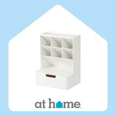 a white shelf with several compartments in it and the words at home above it that says,