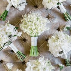 the bridal bouquets are arranged on the back of a couch with white flowers