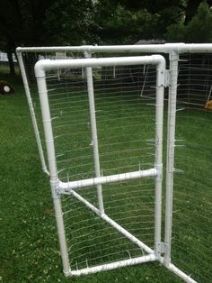 a large white metal fence in the grass