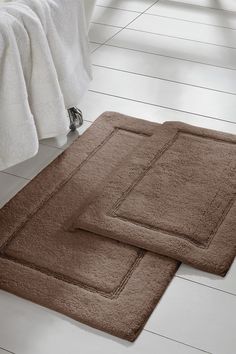 two bath mats sitting on the floor next to each other