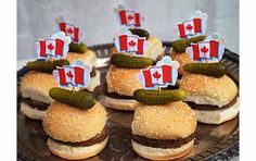 small sandwiches with canadian flags on them are sitting on a plate, ready to be eaten