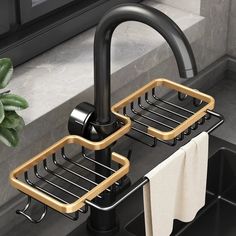 two black and gold sink faucets in front of a window with towels hanging on the rack