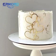 there is a white cake with gold hearts on it