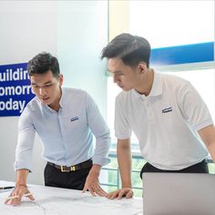 two men looking at a blueprint on a table