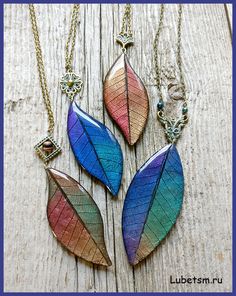 three necklaces with different colored leaves on them