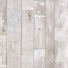 an old white wood wall with peeling paint on the side and wooden planks in the middle