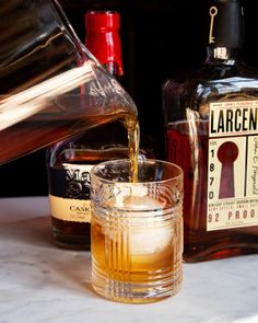 a glass filled with liquid next to bottles