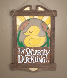 a wooden sign hanging on the wall saying, the snuggly ducking