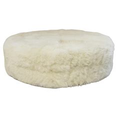 a white sheepskin dog bed on a white background