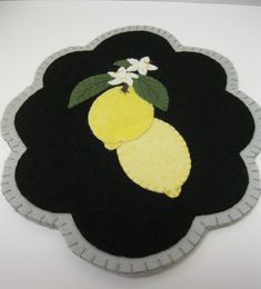 a piece of felt with lemons and flowers on it, in the shape of a flower