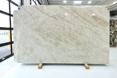 a large marble slab is on display in a warehouse with black and white granite behind it