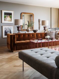 a living room filled with lots of furniture and pictures on the wall next to a window