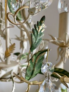 a chandelier with leaves and crystals hanging from it