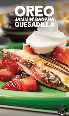 a dessert with strawberries, chocolate and whipped cream is on a green plate next to cookies