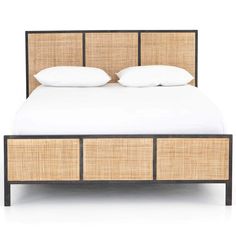 the bed is made up with wicker and white linens on top of it