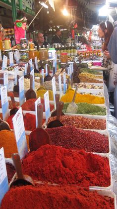 many different kinds of spices on display at a market