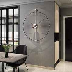 a dining room table with chairs and a large clock mounted to the wall above it