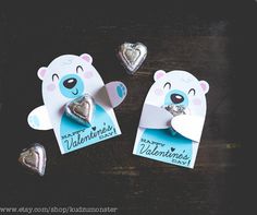 two valentine's day cards with silver foil hearts and a bear holding a heart