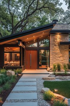 a modern house with stone steps leading to the front door