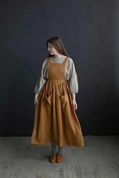 Cottage dress is made from 100% soft and washed linen. Details: - Colour: Mustard - Composition: 100% Oeko-Tex certified linen - Pockets - Cross back - Length - 124 cm (49 inches) - Adjustable with buttons - Elastic Waist - Medium weight linen - Linen care: machine wash gentle; tumble dry low, ironing optional - The price is for one pinafore dress, other pictured items are not included Victorian Apron, Victorian Aprons, Linen Pinafore Dress, School Uniform Dress, Cottage Dress, Farm Dress, Linen Pinafore, Pinafore Apron, Cottagecore Outfits