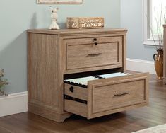 two drawers are open in the corner of a room with blue walls and hardwood floors