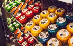 a display case filled with lots of different types of juices and drinks in cans