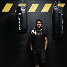 a man standing next to two boxing bags