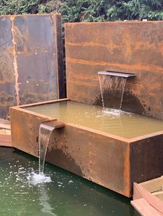 the water is running out of the trough into the pond