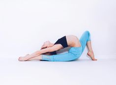 a woman is sitting on the floor with her legs crossed and arms behind her back