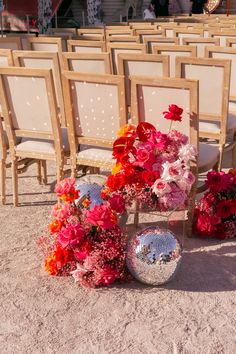 an arrangement of flowers on the ground in front of rows of chairs