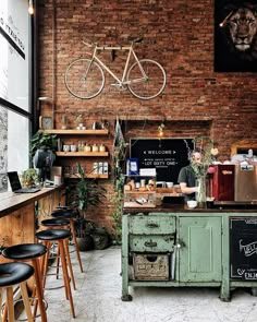 a bicycle mounted to the wall in a coffee shop with lots of shelves and stools