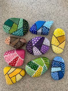 colorful rocks are arranged on the ground in different colors and patterns, with dots all over them