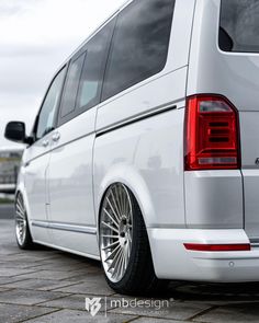 the rear end of a white van parked in a parking lot