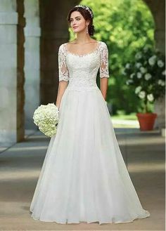 a woman in a wedding dress standing outside